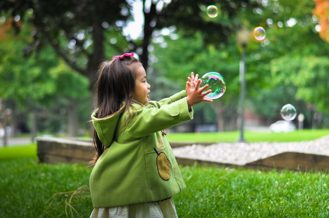 Como Viajar com Crianças: Dicas para Nômades Digitais - Web Nômade Digital selective photo of a girl holding bubbles