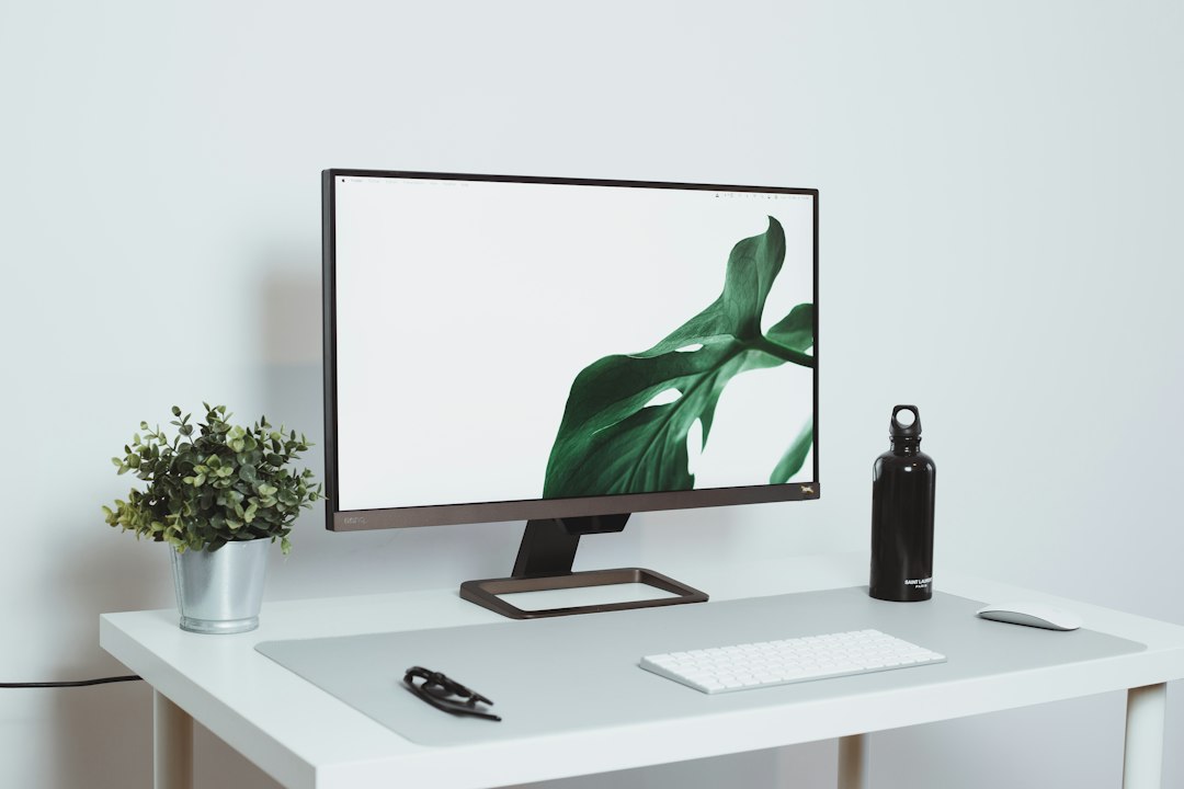 Como Montar um Setup Minimalista para Trabalho Remoto - Web Nômade Digital a computer monitor sitting on top of a white desk