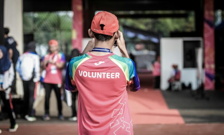 Como Viajar e Trabalhar em Projetos de Voluntariado Internacional - Web Nômade Digital person standing wearing red shirt