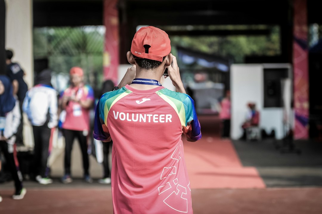 Como Viajar e Trabalhar em Projetos de Voluntariado Internacional - Web Nômade Digital person standing wearing red shirt