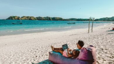 Os 5 Melhores Destinos para Nômades Digitais em 2025 - Web Nômade Digital a man sitting on a bean bag on the beach