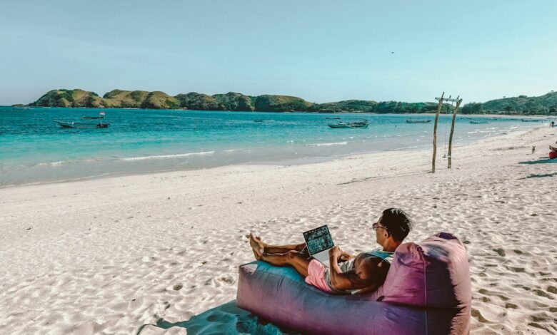 Como Gerenciar seu Tempo para Trabalhar e Viajar com Eficácia - Web Nômade Digital a man sitting on a bean bag on the beach
