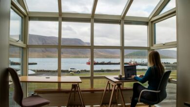 person in blue jacket sitting on brown wooden chair near brown wooden table during daytime