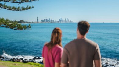 Two people looking at the Gold Coast skyline across the blue ocean
