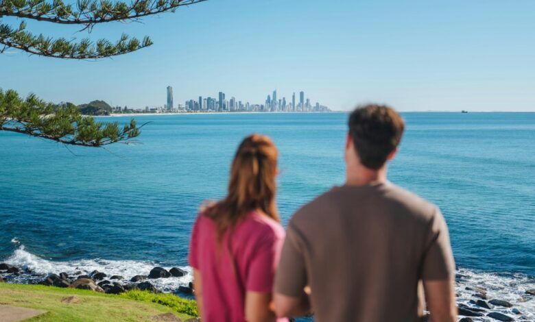 Two people looking at the Gold Coast skyline across the blue ocean