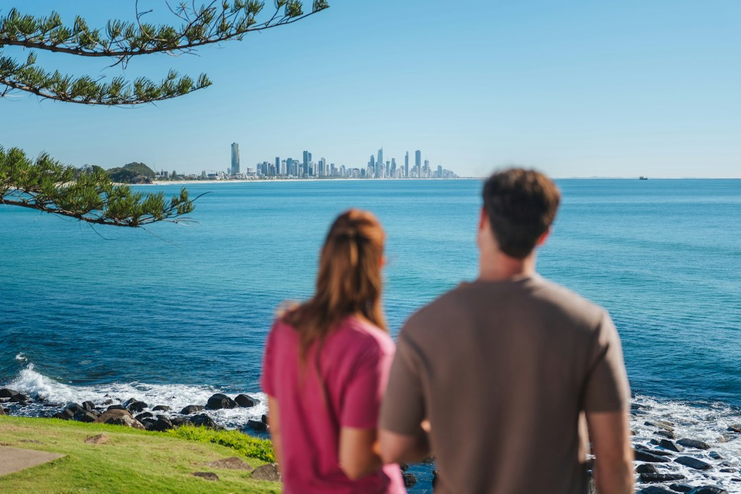 Como Aproveitar o Trabalho em Eco-Turismo para Nômades Digitais - Web Nômade Digital Two people looking at the Gold Coast skyline across the blue ocean