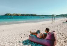 a man sitting on a bean bag on the beach