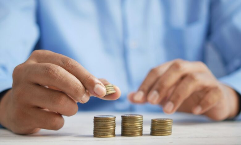 5 Dicas para Investir em Criptomoedas como Nômade Digital - Web Nômade Digital a person stacking coins on top of a table