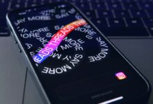 a close up of a cell phone with a keyboard in the background