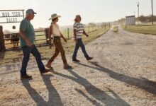 Three farmers walking across a farmyard